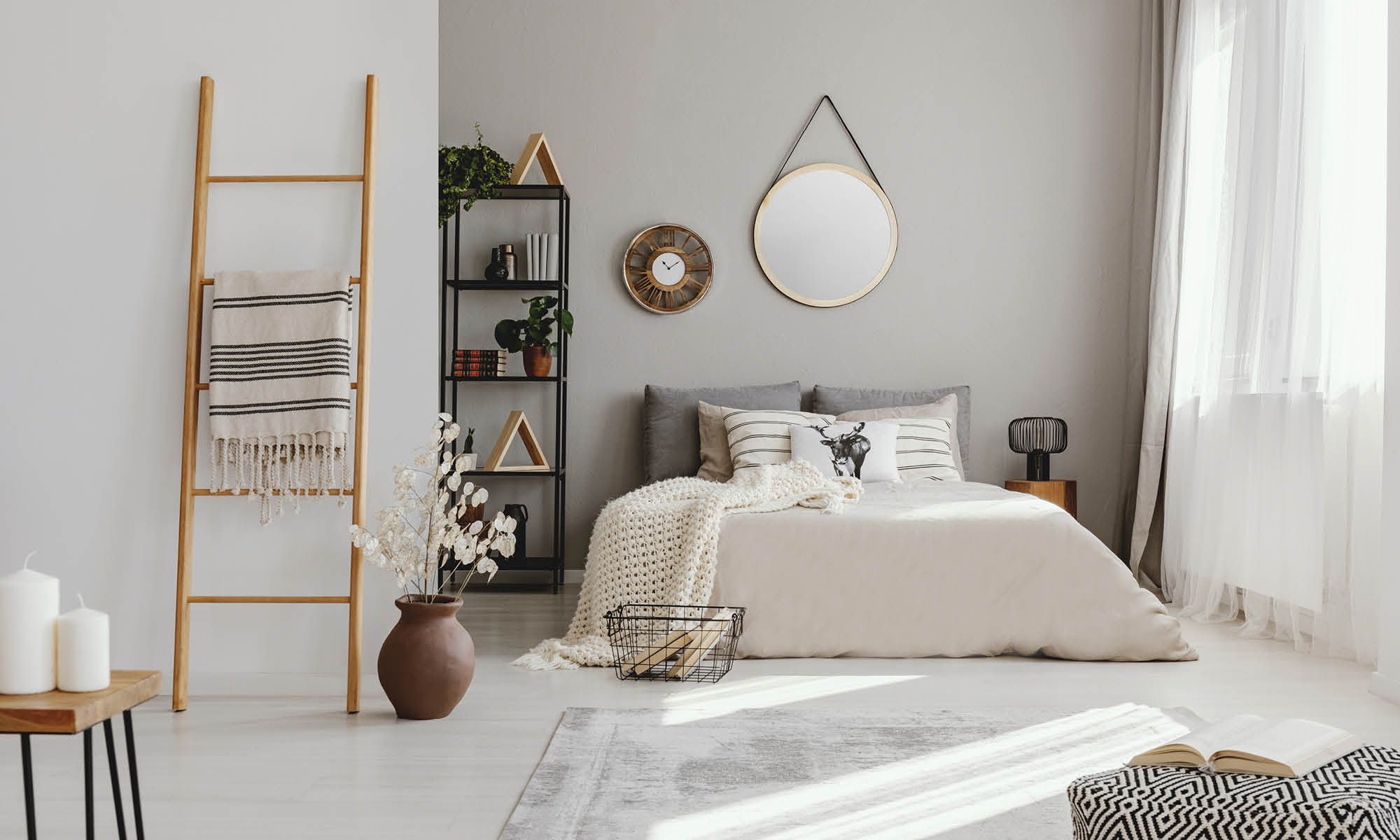 Modern minimalist bedroom with natural light, neutral tones, and decorative shelving.