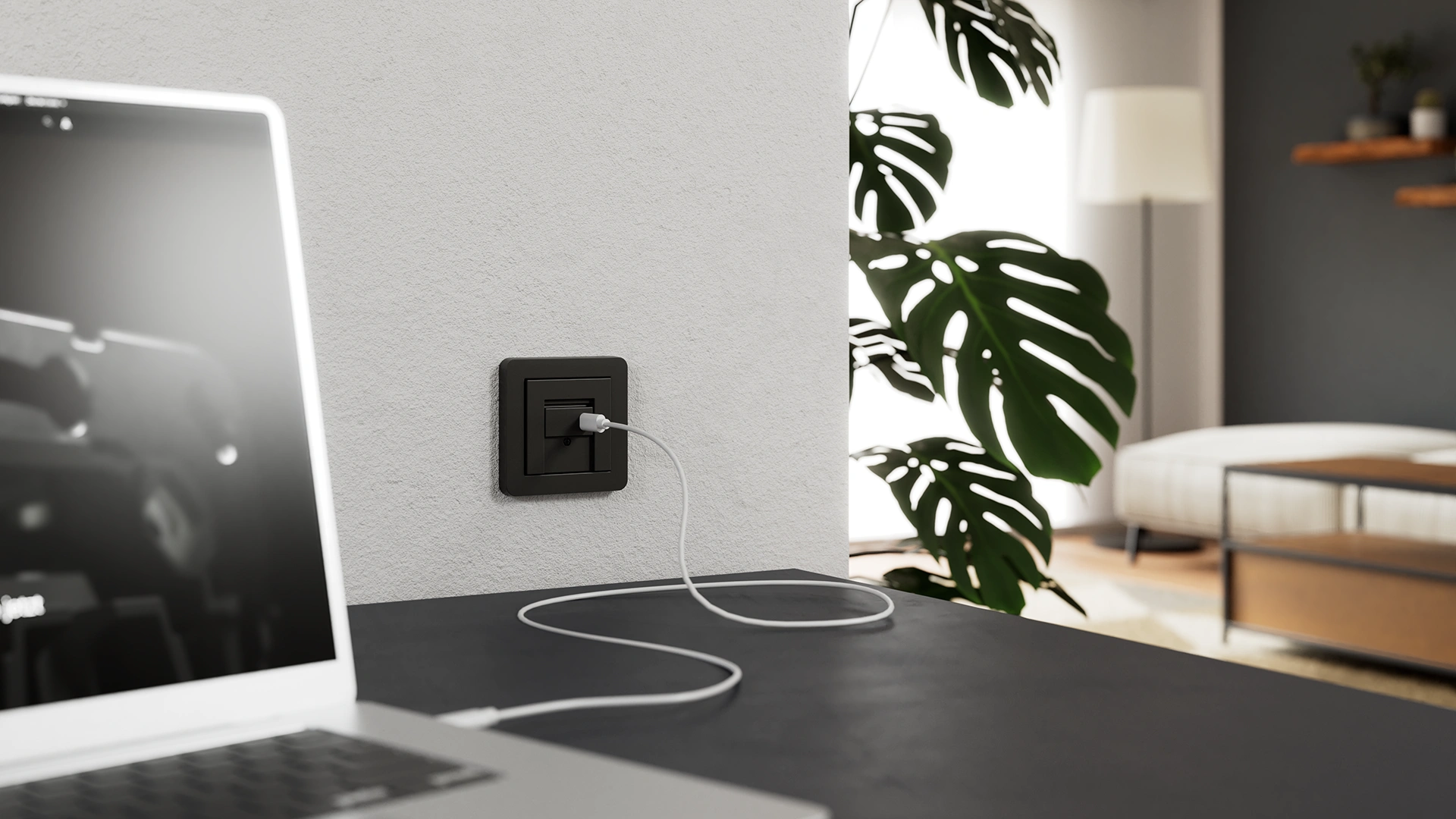 Gira USB-C-Spannungsversorgung mit Power Delivery in Schwarz, installiert an einer weißen Wand in einem modernen Homeoffice.