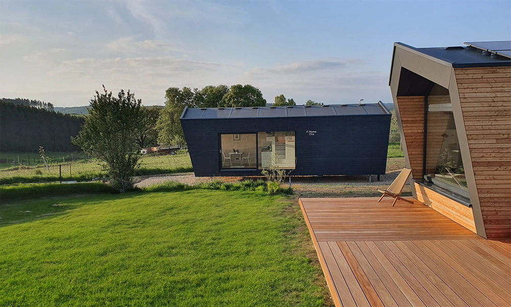 Ein Tiny House in schwarz gehalten in ländlicher Umgebung.