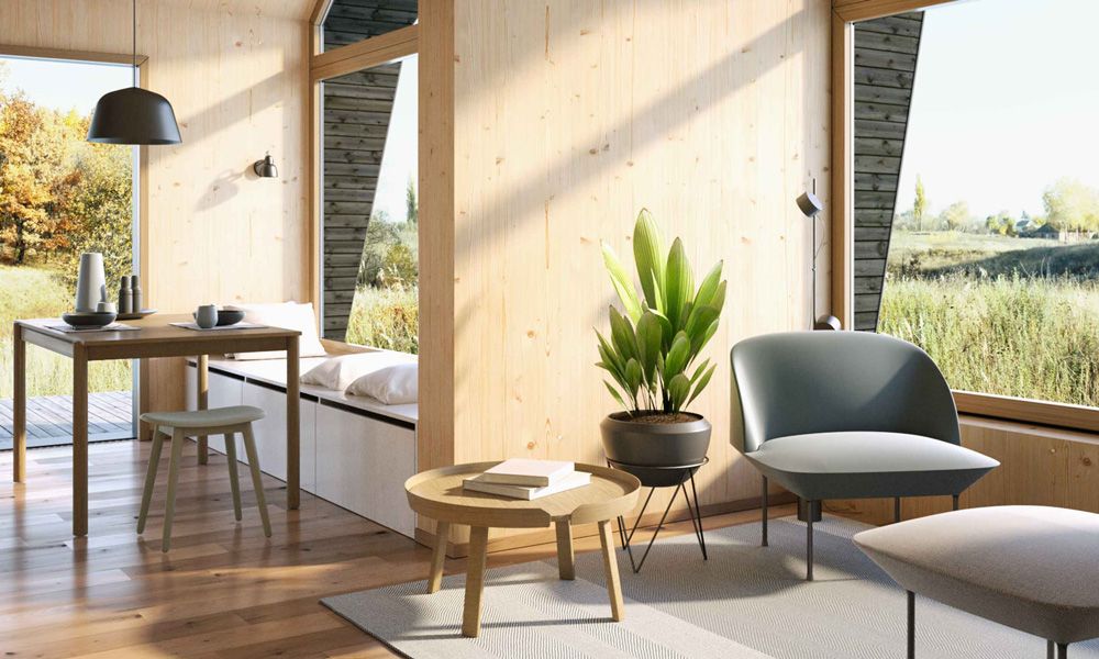 Gemütlicher Wohnbereich im Cabin One mit viel Holz, Designmöbeln und Blick ins Grüne.