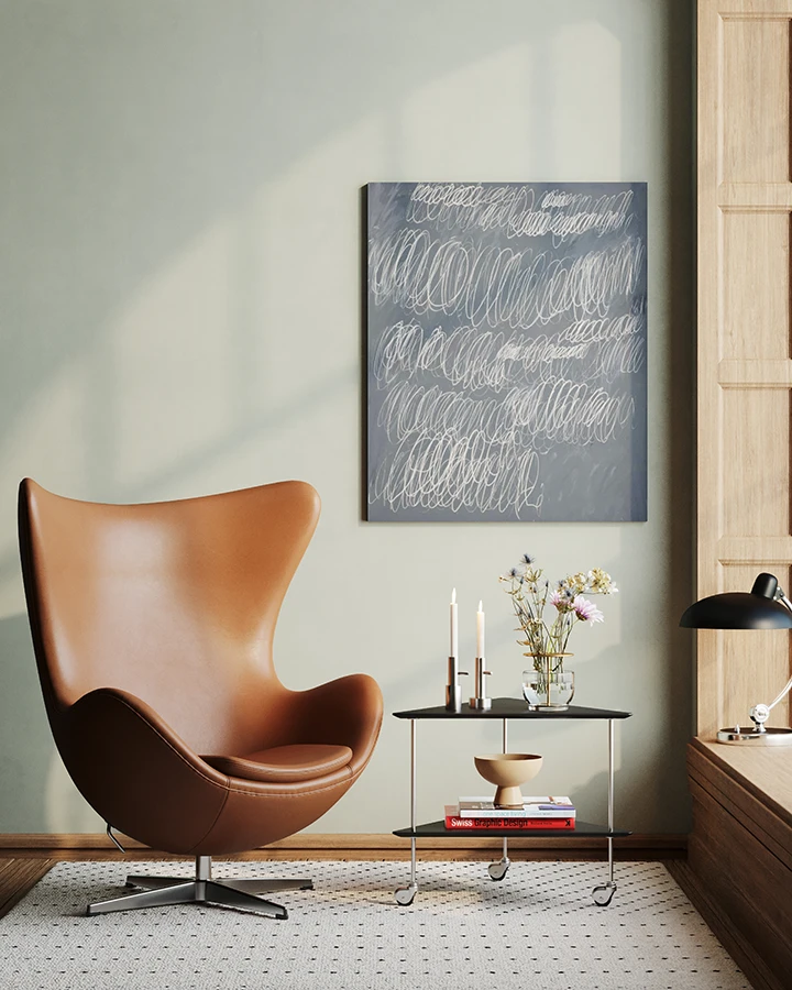 Eine elegante Leseecke im Mid-Century-Interior-Stil mit einem braunen Egg Chair aus Leder. 