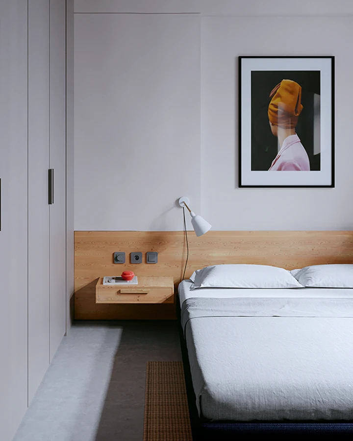 Ein minimalistisches Schlafzimmer im Mid-Century-Interior-Stil mit einem niedrigen Bett, einer schlichten Holzwandverkleidung, integriertem Nachttisch und einer modernen Wandlampe. 