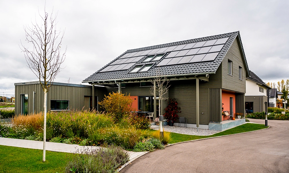 Das Fertighaus Aenne ist energieeffizient gestaltet, mit Solarpaneelen auf dem Dach.
